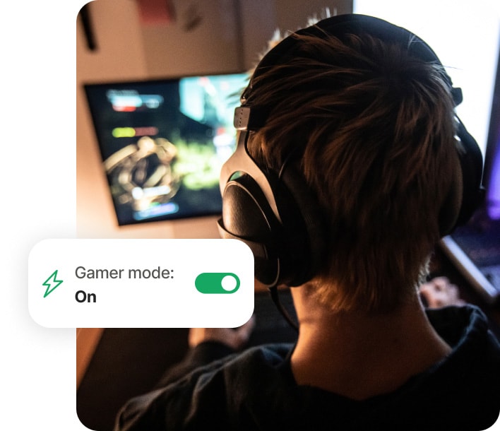 Fiú számítógépen játszik a Norton 360 for Gamers használatával.