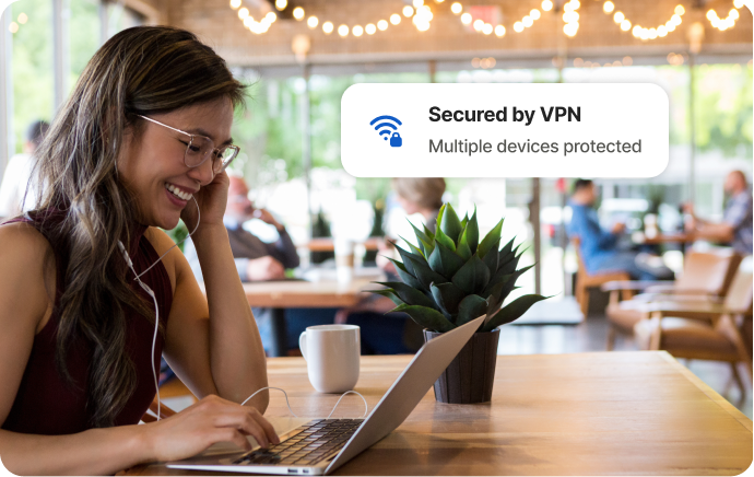 Egy nő egy kávézóban egy laptop képernyőjén nevet