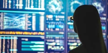 Egy személy adatokat néz egy képernyőn